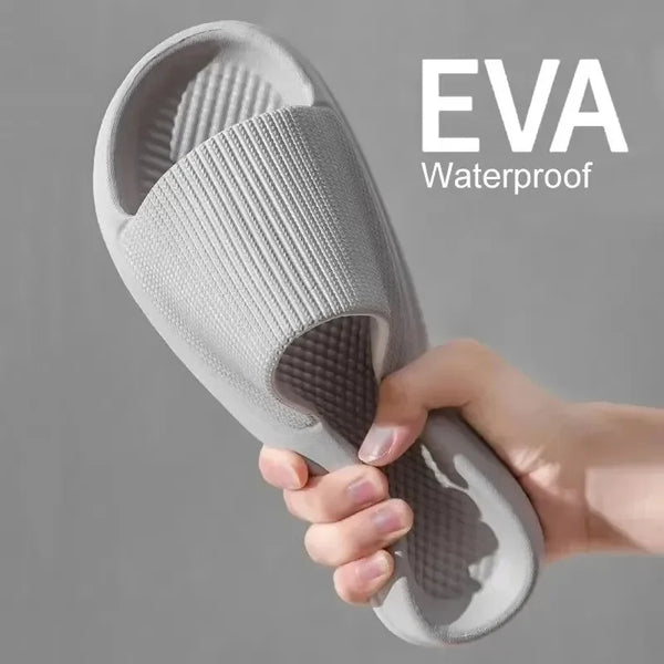 Una mano sostiene una pantufla impermeable antideslizante de ducha de EVA gris.