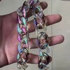 A close-up of a colorful resin chain replacement strap for handbags being held in a hand.