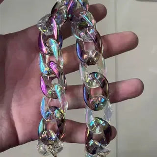 A close-up of a colorful resin chain replacement strap for handbags being held in a hand.