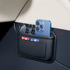 A blue smartphone is stored in a black car seat side pocket organizer with various accessories.