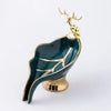 A glossy green ceramic soap dish shaped like a leaf with a gold drain rack.