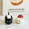 A white cat-shaped soap box with a drainage tray sits in front of text about making bread every day.