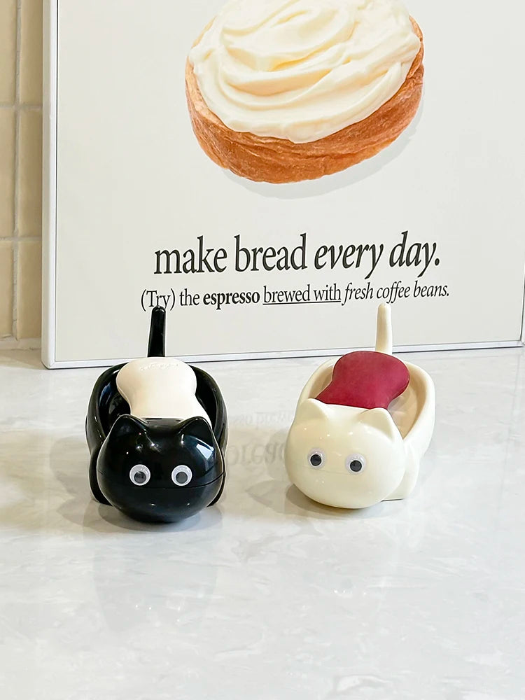 A white cat-shaped soap box with a drainage tray sits in front of text about making bread every day.