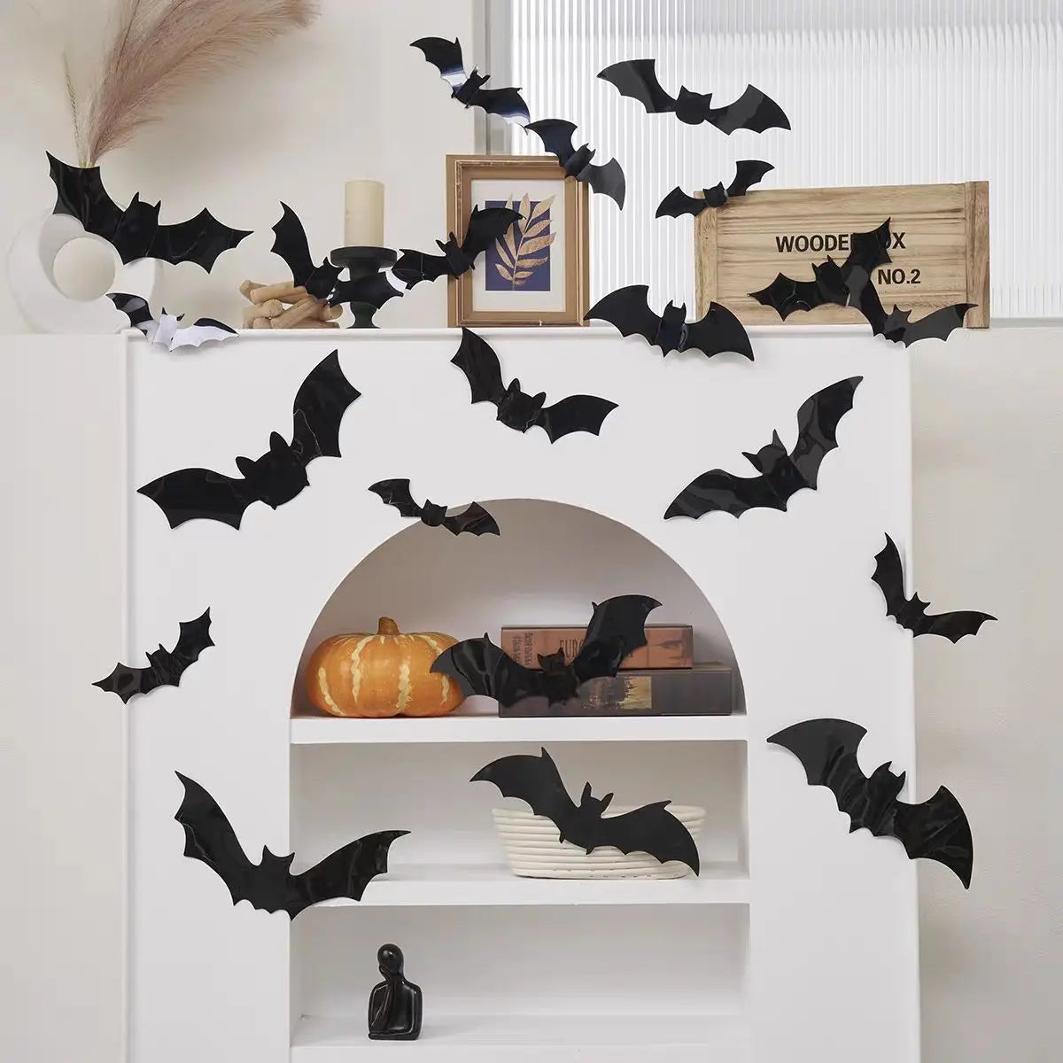 Black bat wall stickers with LED lights decorating a white shelf display.