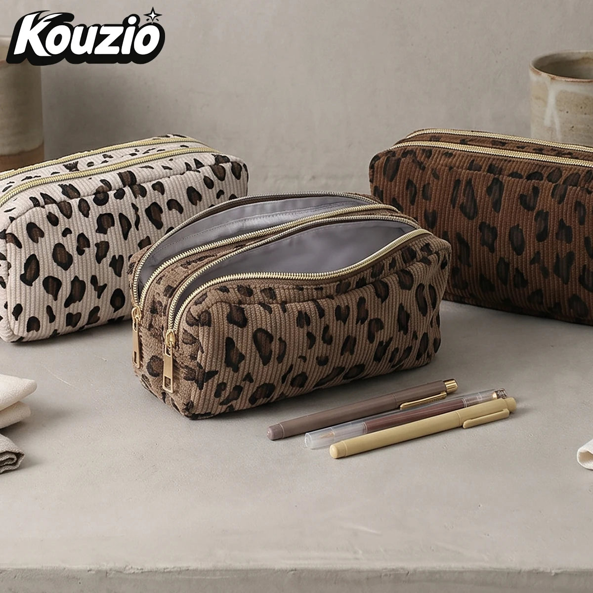 A brown leopard print double-zip pencil case with a gray lining is shown on a light surface.