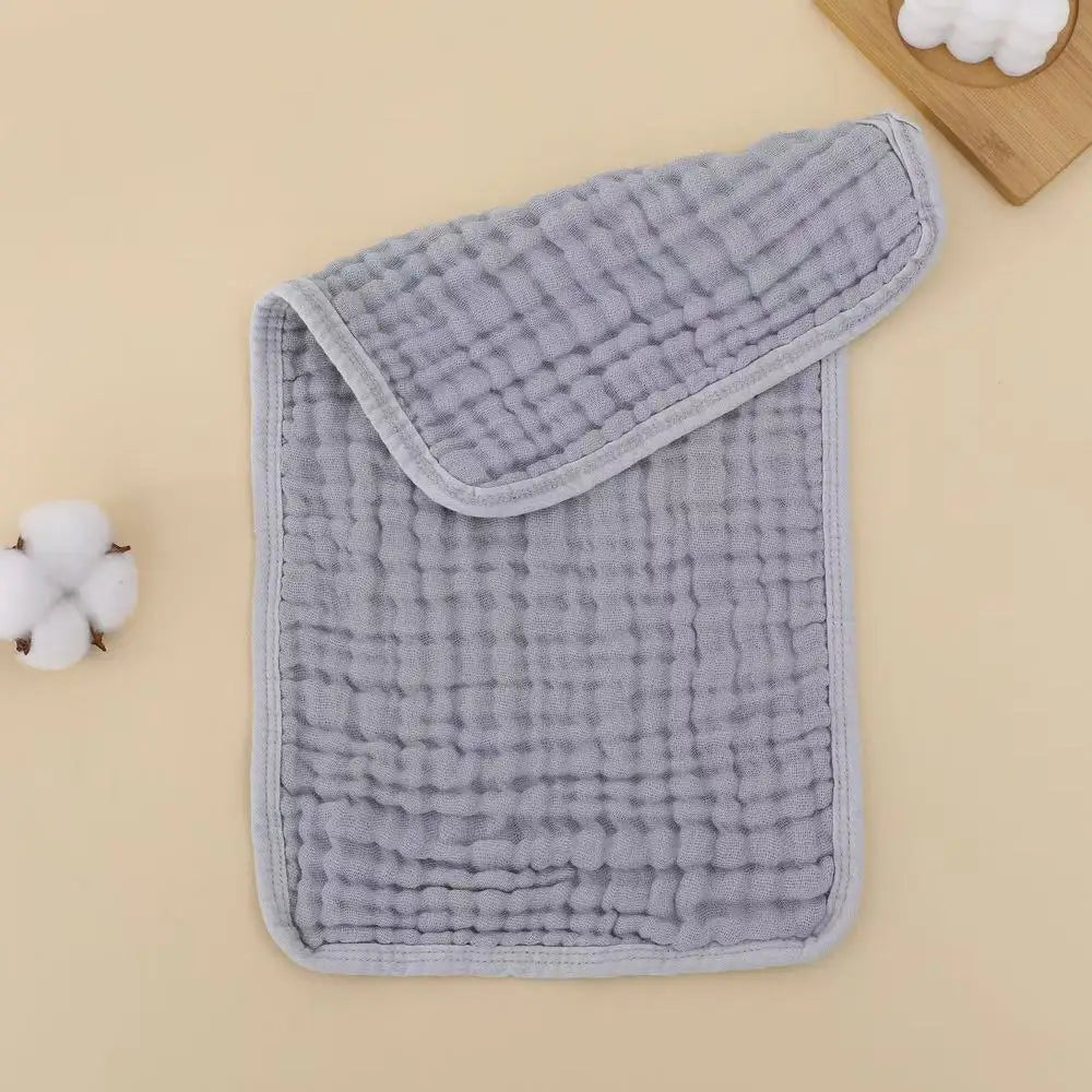 A gray muslin baby burp cloth with a rounded edge is shown on a light background.
