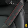 Close-up of a black PU leather embossed seat belt shoulder cushion with red stitching on a vehicle seat.