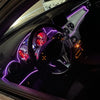 Interior view of a car showing purple LED light strips installed on the dashboard and steering wheel.
