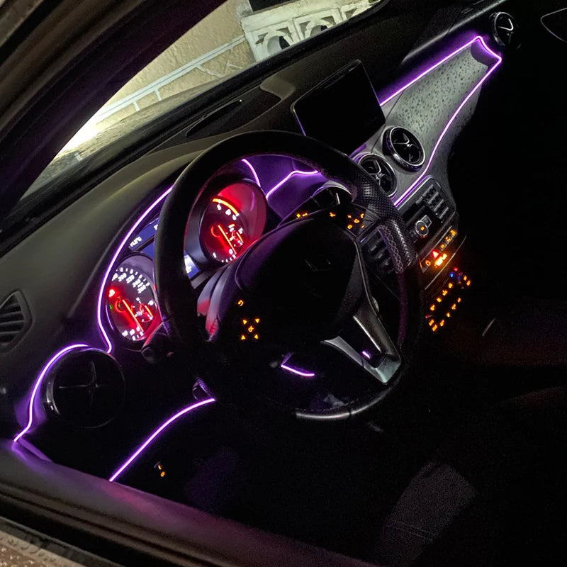 Interior view of a car showing purple LED light strips installed on the dashboard and steering wheel.