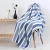 A folded blue and white striped microfiber towel draped over a wooden hanger.