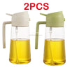 Two glass oil spray bottles with white and green tops for cooking