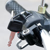 Close-up of a black anti-theft helmet lock mechanism mounted on a bicycle handlebar.