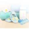 A light blue stroller organizer bag with a cup holder is shown next to a rolled towel and a bottle.
