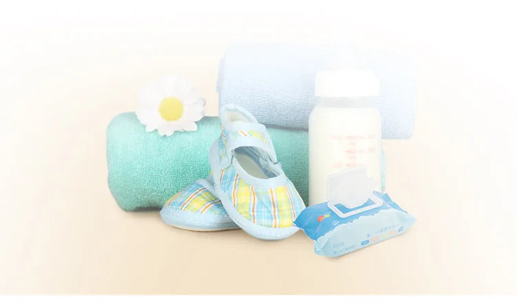 A light blue stroller organizer bag with a cup holder is shown next to a rolled towel and a bottle.