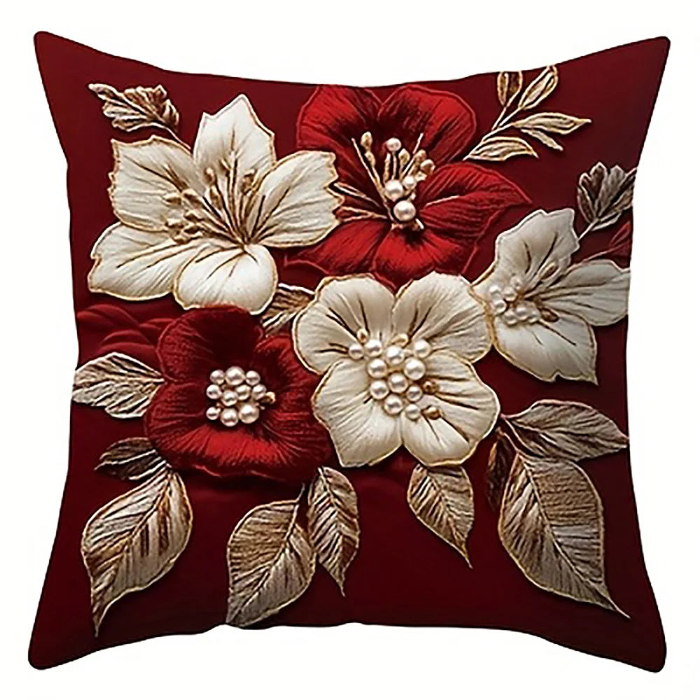 A decorative pillow featuring red and cream floral embroidery on a dark red fabric.