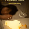 A glowing silicone duck night light is placed on a table, illuminating the area.