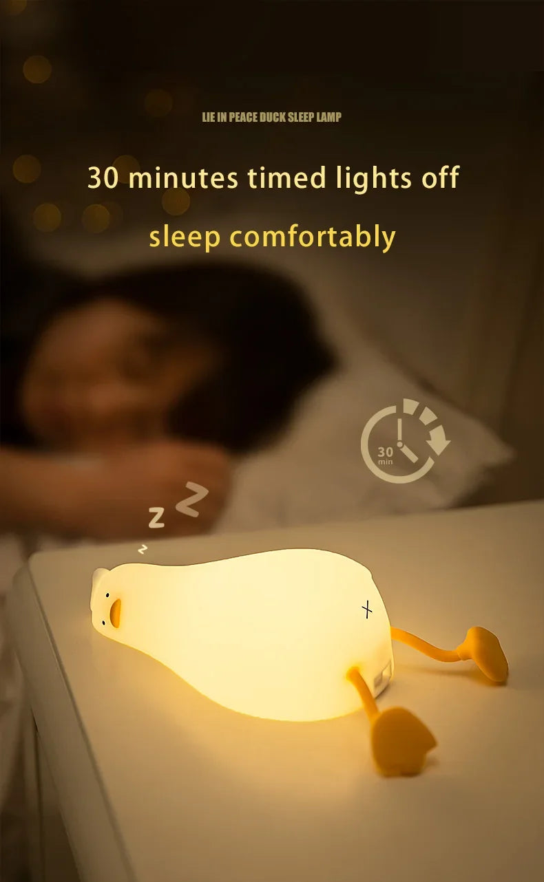 A glowing silicone duck night light is placed on a table, illuminating the area.