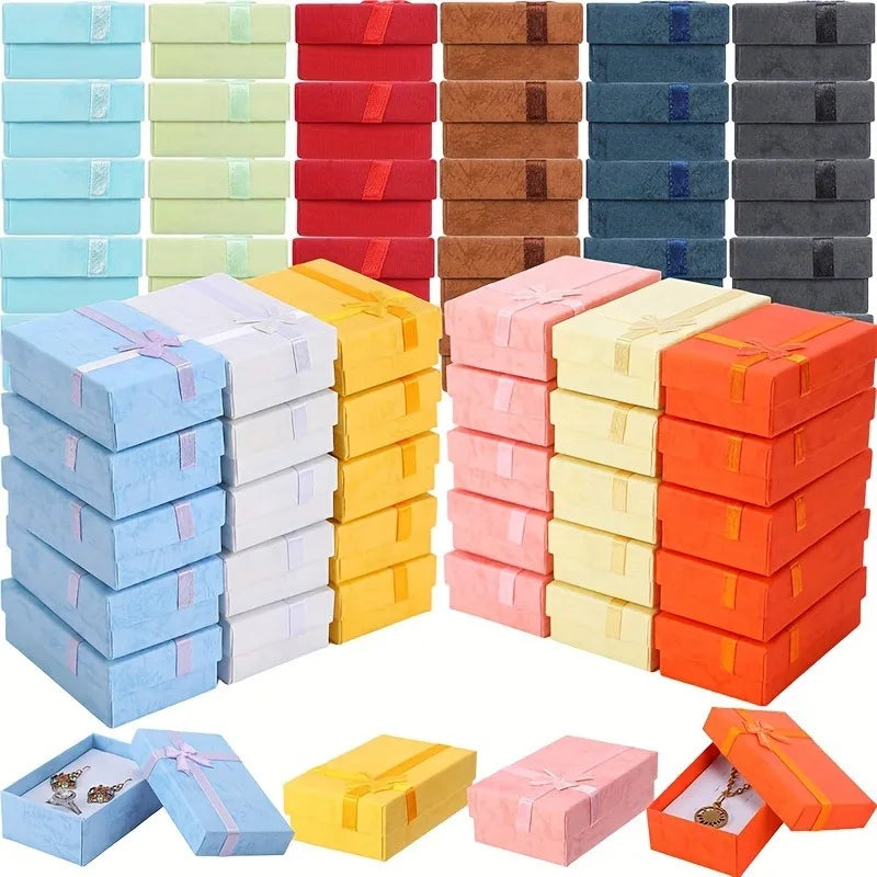 Assorted velvet jewelry gift boxes in various colors including blue, green, yellow, pink, and orange.