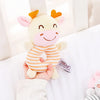 A hand holds a soft plush baby rattle toy shaped like an orange and pink cartoon animal.