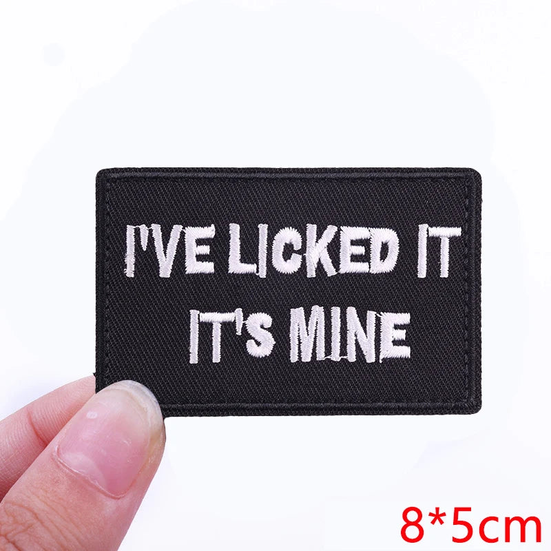 Black embroidered iron-on letter patch with white text that reads I've licked it it's mine
