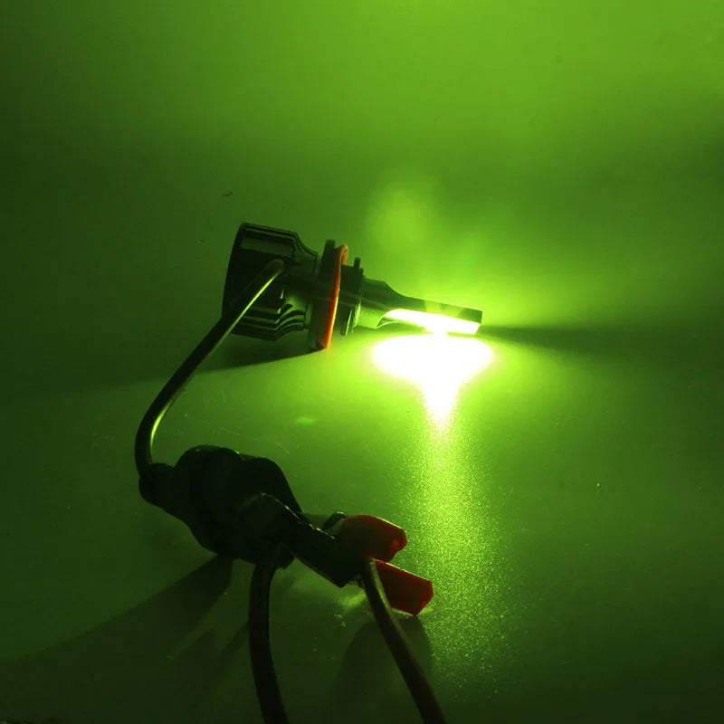 A bright green LED headlight bulb emitting a strong beam against a dark background.