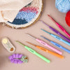 A set of seven aluminum alloy crochet hooks with ergonomic handles in various colors and sizes displayed on a pink background
