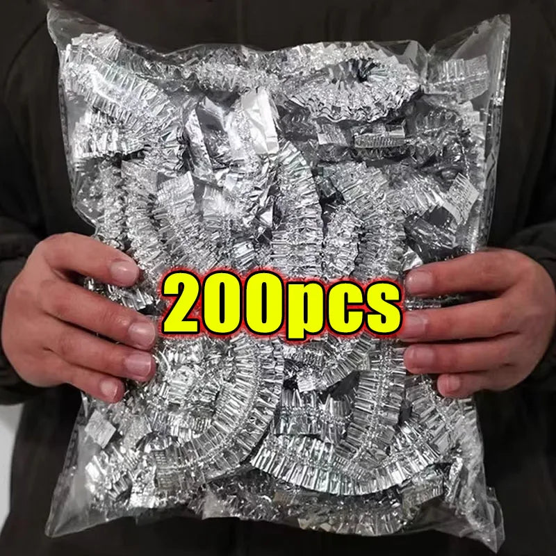 Eine Hand hält einen durchsichtigen Plastiksack gefüllt mit 200 wiederverwendbaren Aluminium-Essacks zur Wärmespeicherung.