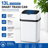 A white 13L waterproof smart trash can with a black lid, shown next to a potted plant.
