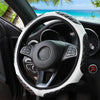 A close-up view of a black steering wheel with a white faux sheepskin cover, showing the interior and dashboard.