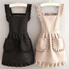 A black Korean style cotton kitchen apron with adjustable neck strap and ruffled details.