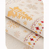 Close-up of Christmas tree patterned chenille sofa covers with anti-slip backing shown in a rolled view.