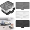 A set of self-draining silicone soap trays in gray, white, and black showing various shapes and elevated ridges.