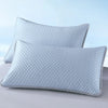 A light blue quilted pillowcase is shown lying on a white surface.