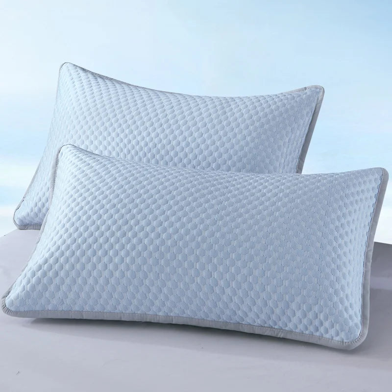 A light blue quilted pillowcase is shown lying on a white surface.