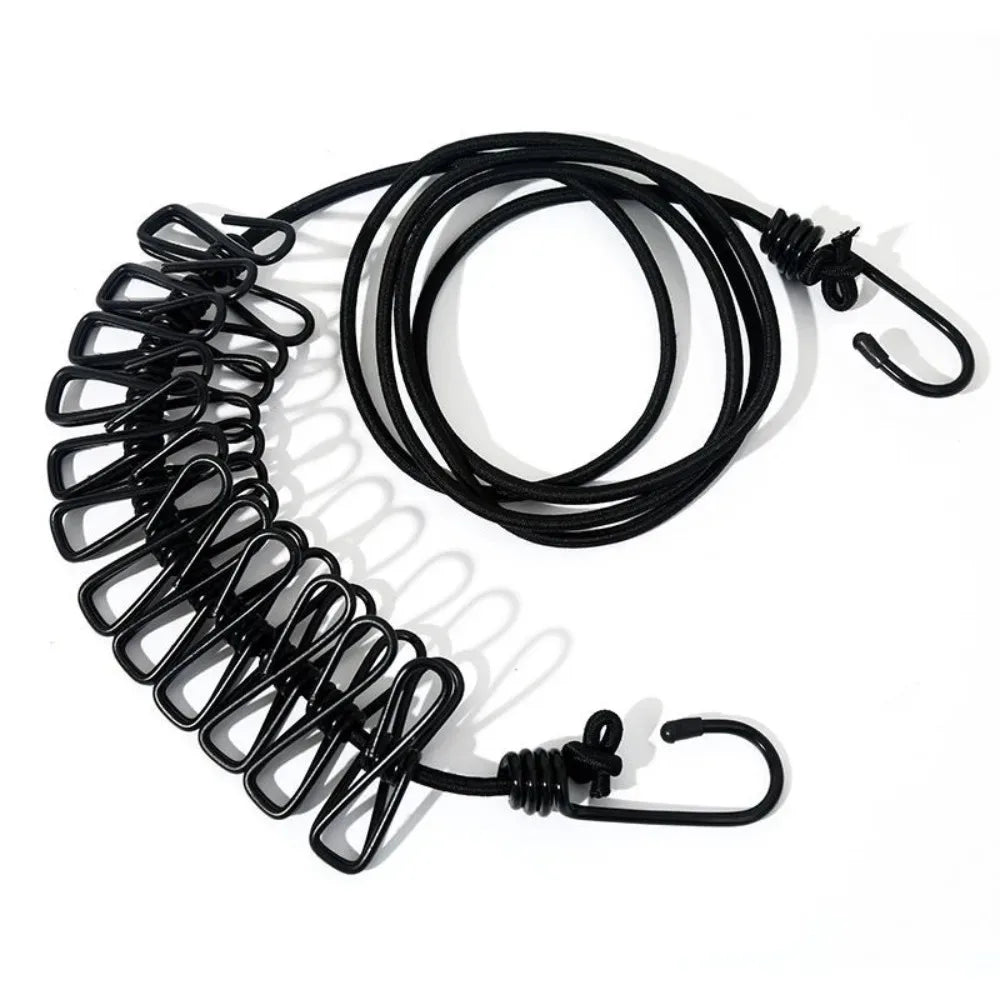 Black elastic travel clothesline with non-slip clips coiled and laid out.