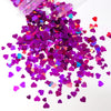 A pile of shiny holographic purple and pink heart-shaped sequins for resin crafts.