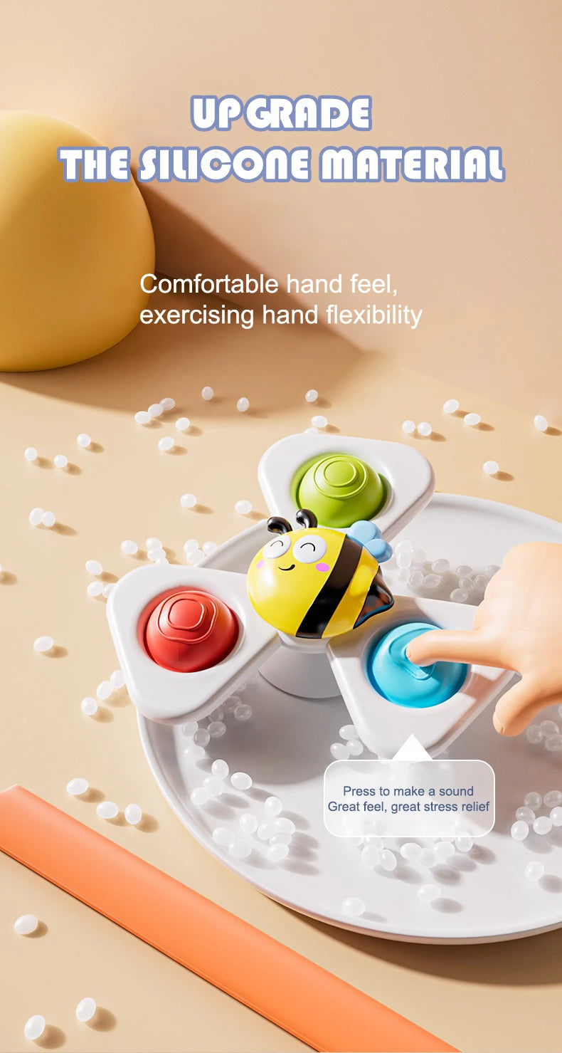 A hand is pressing a colorful silicone bath toy on a plate to make a sound for stress relief.