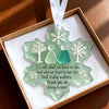 A handcrafted sea glass ornament shaped like a snowflake, featuring silhouettes of two people and a message of appreciation.