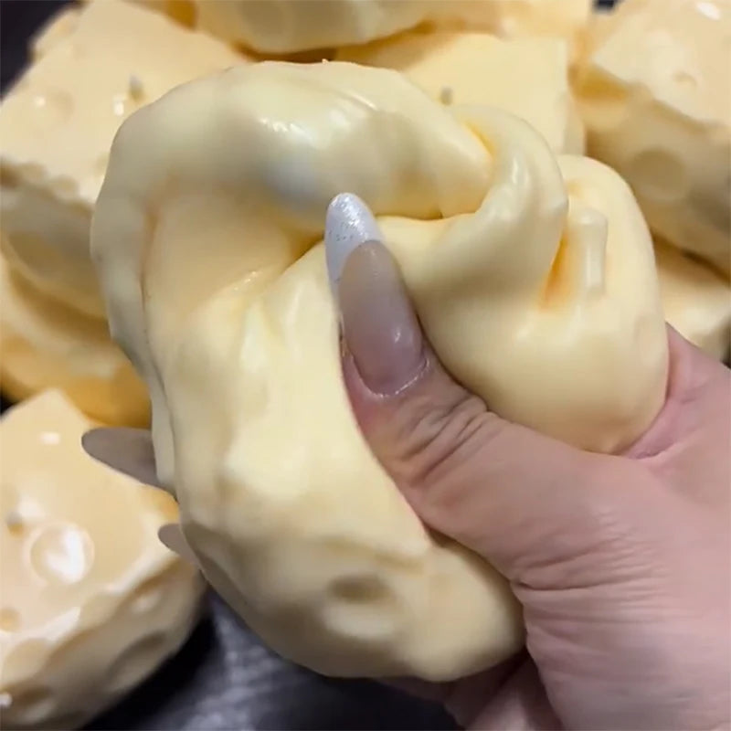Eine Hand drückt ein cremefarbenes, gelbes Stressball-Spielzeug.