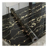 A black marble roll self-adhesive wall sticker with gold veining displayed on a dark surface.