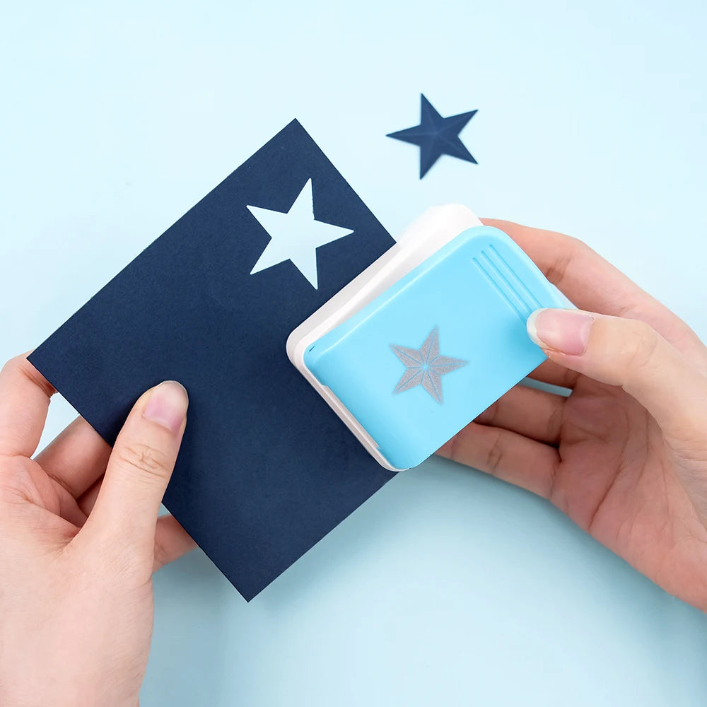 A hand holds a blue embossing punch next to a dark blue stamp on a light blue background.