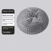 A close-up view of a metal wire ball cleaning brush with a built-in soap dispenser.