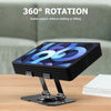 A black 360° rotating adjustable tablet stand supporting a tablet on a wooden table.