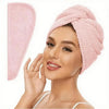 A woman is wearing a pink microfiber hair drying towel wrap on her head.