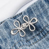 Silver adjustable clover buckle attached to denim fabric