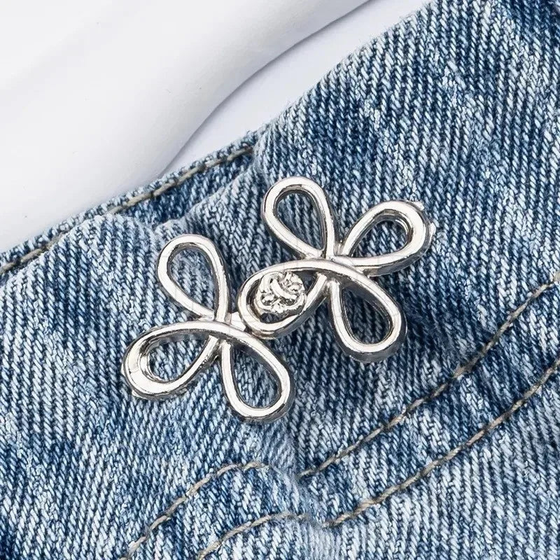 Silver adjustable clover buckle attached to denim fabric