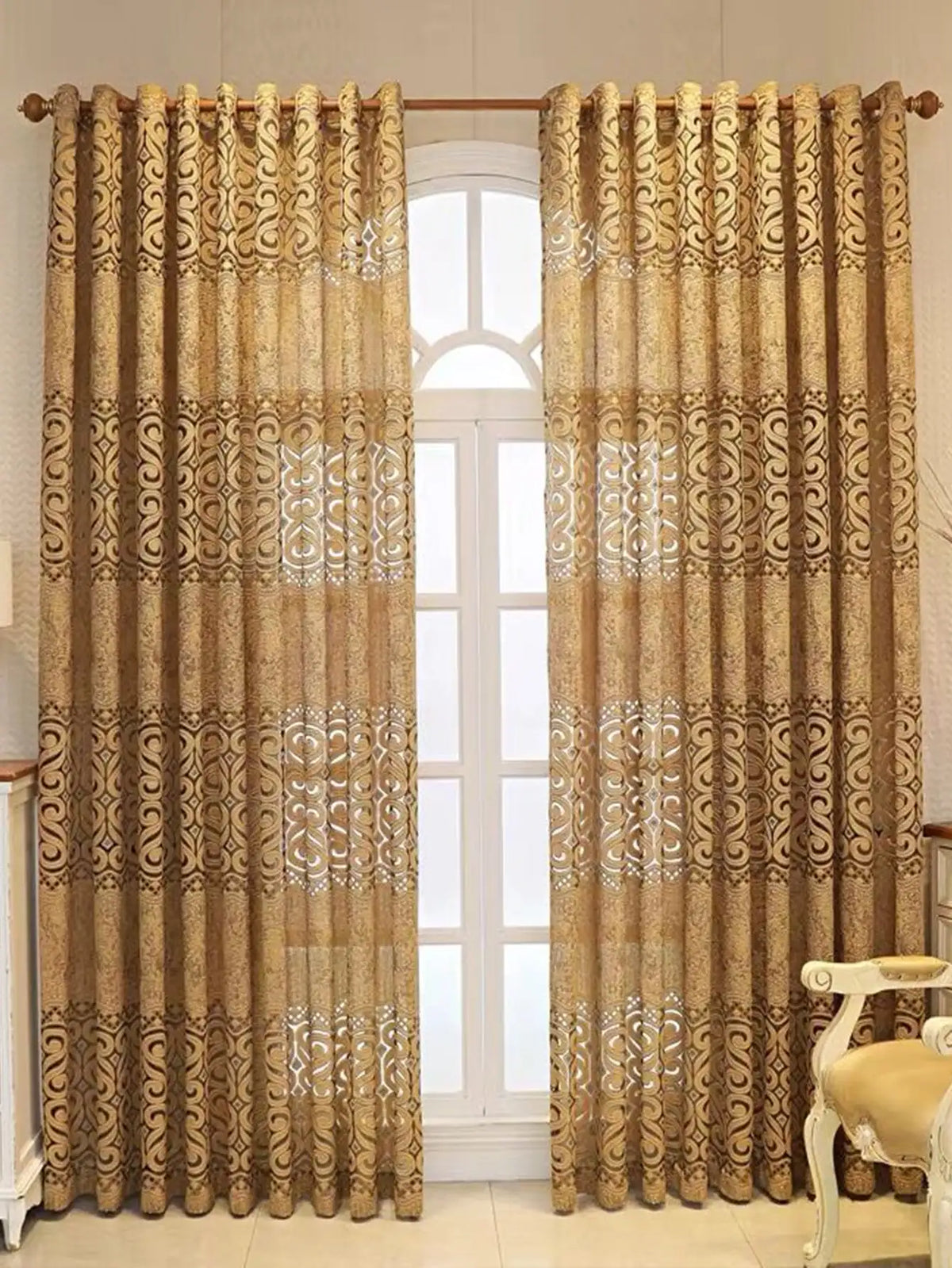 Paar beige gemusterter, durchscheinender Vorhänge in einem weißen Fensterrahmen