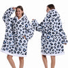 Eine Frau modelliert einen Oversized-Fleece-Hoodie mit Leopardenmuster in Weiß und Schwarz mit Kapuze.