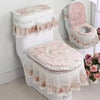 A white toilet seat cover set with a washable cushion featuring lace trim and floral embroidery.