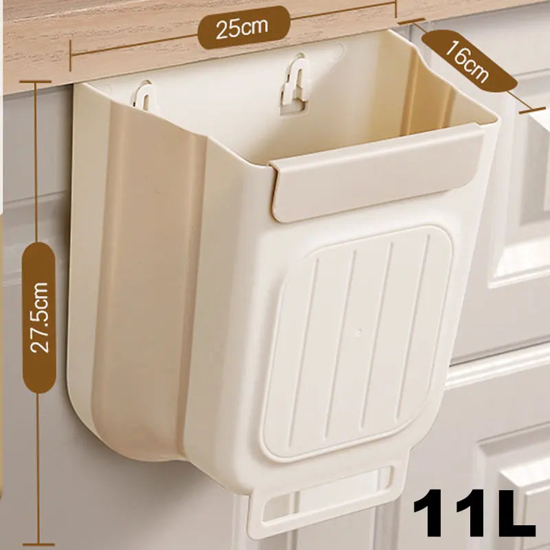 A beige foldable hanging trash can with a ribbed front is mounted on a wooden cabinet shelf.